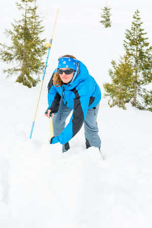 Female rescuer searching for avalanche victim.の写真素材