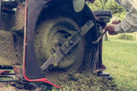 Man cleaning lawn mower blade.の写真素材