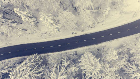 Aerial view of road through a winter forest.の写真素材