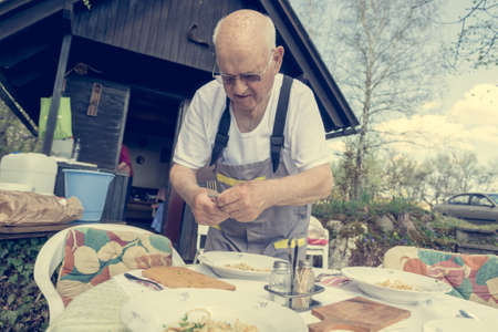 Elderly man setting a table outside.の写真素材