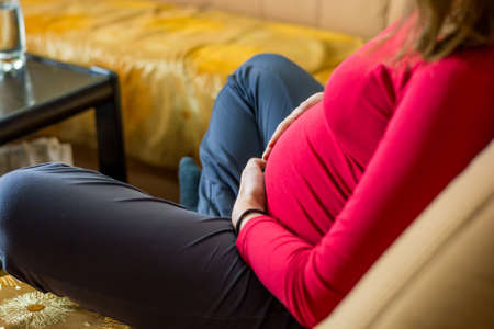 Closeup of mother holding her pregnant belly.の写真素材