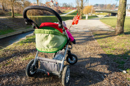 Rear view of a baby stroller with red pinwheel.の写真素材
