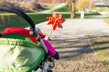 Rear view of a baby stroller with red pinwheel.の写真素材