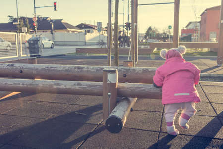 Child exploring outdoor gym and learning to stand.の写真素材