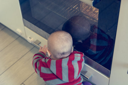 Child pushing at active oven.の写真素材