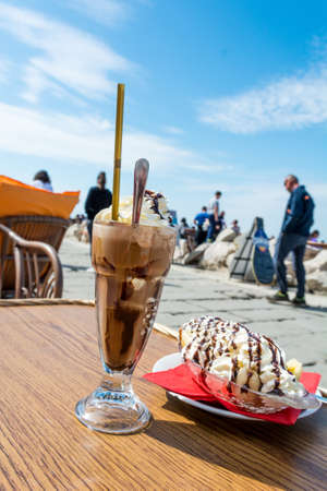 Enjoying ice coffee with banana split ice cream.の写真素材