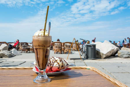 Enjoying ice coffee with banana split ice cream.の写真素材