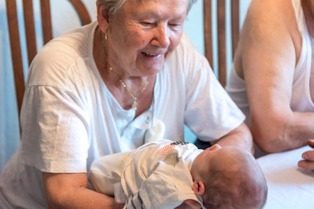 Happy grandmother caressing newborn baby.