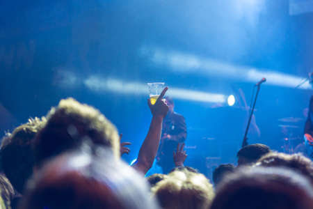 Raised beer glass at a concert.の写真素材