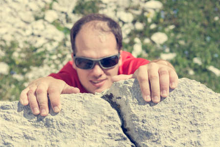 Male climber hanging from a rock.の写真素材