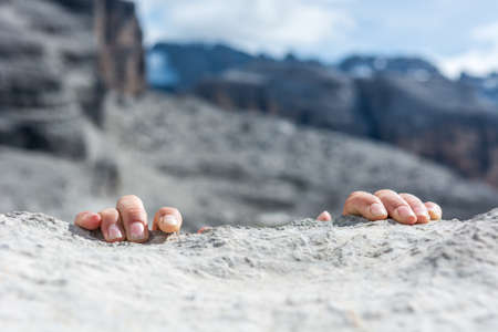 Closeup of fingers gripping a rock.の写真素材
