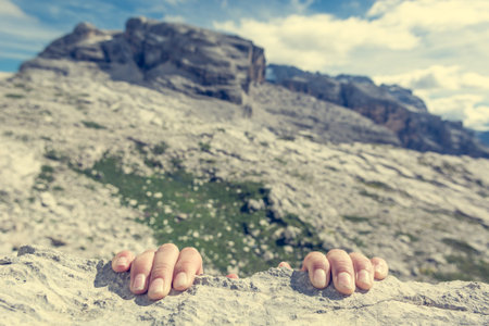 Closeup of fingers gripping a rock.