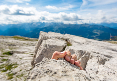 Closeup of fingers gripping a rock.