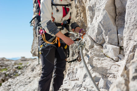 Closeup of female climber attaching via ferrata set.