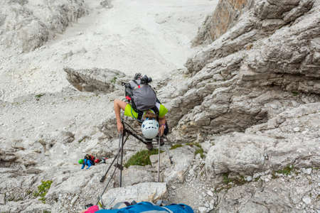 Climbers tackling via ferrata metalic ladder.の写真素材