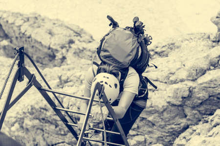 Climbers tackling via ferrata metalic ladder.の写真素材