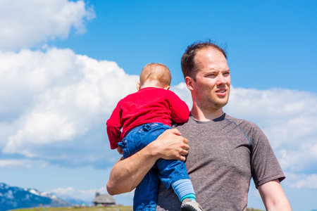 Young father holding daughter in his arms.