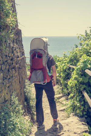 Active father with his child in backpack hiking.