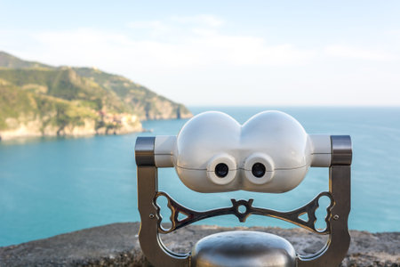 Tourist coin operated binoculars at sea looking at a distant town.
