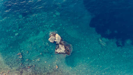 Drop down view of blue sea with rocks.の写真素材