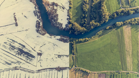 Aerial view of season change with river bend.