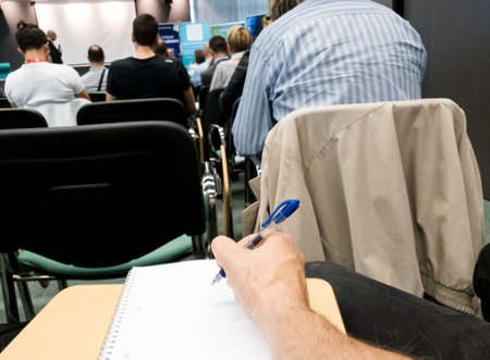 Taking notes at a conference with blue pen.の写真素材