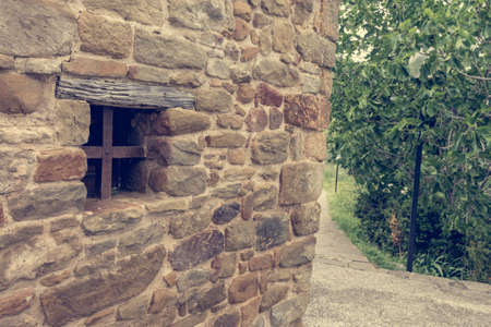 Detail of traditionaly built window in stone building with metal bars.の写真素材