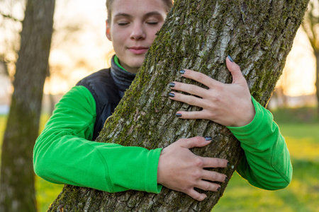 Portrait of caucasian female holding a tree trunk.