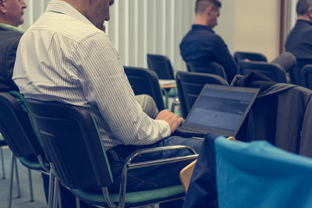 Taking notes on a laptop at conference.