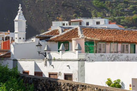 Traditional coastal architecture rooftops with vulcanic bacground.の写真素材