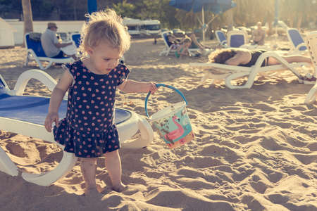 Cute little girl playing on sandy beach and exploring.の写真素材