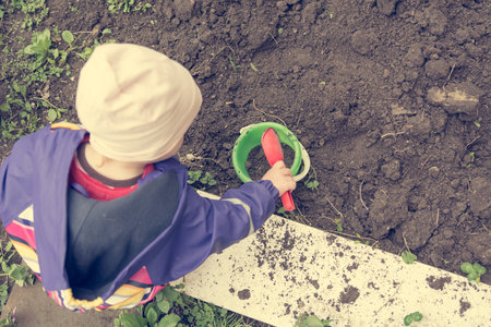 Small girl exploring the garden and helping with spring cleaning.