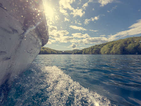 Side view of boat cruising along lake from just above the water. Plitvice national park, Croatia.の写真素材