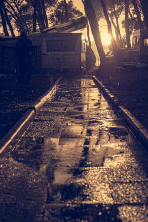 Sunset reflecting in rain ponds after thunder storm hit camping ground.の写真素材