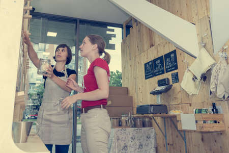 Female shopkeeper helping a customer in zero waste store.の写真素材