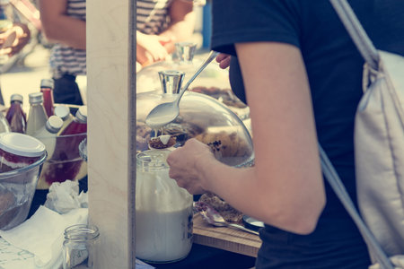 Serving customers at outdoor market with healthy local products.の写真素材