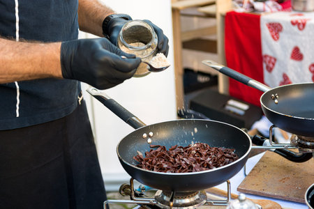 Chef preparing delicious organic pasta dish outdoor.