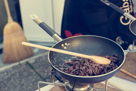 Chef preparing delicious organic pasta dish outdoor.