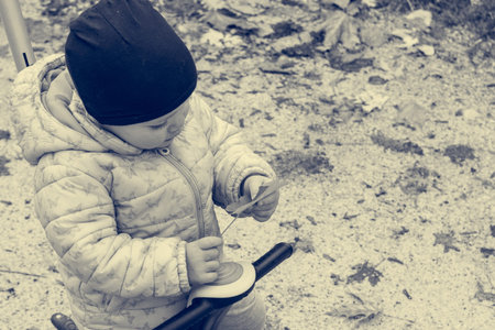 Small girl exploring autumn leaves - exploring colors and texture.