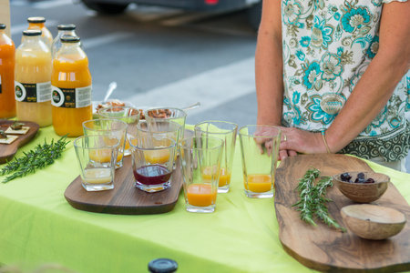 Delicious organic juices served at outdoor market place. Drinking local products.