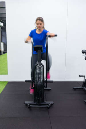 Motion blur concept of female fitness trainer performing on attack bicycle.の写真素材