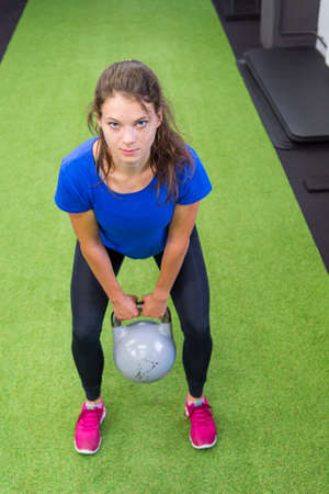 Young female performing various excercies using kettlebell.の写真素材