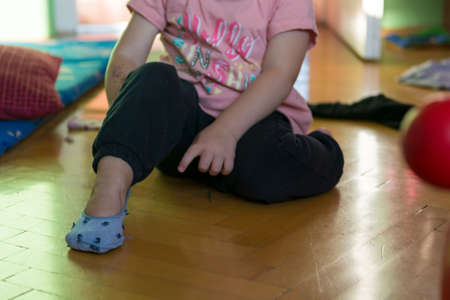Young girl learning how to put her socks on.の写真素材