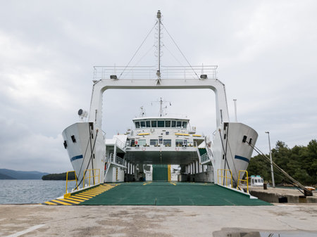 Ferry boat docked in a harbour with opened gates ready to be boarded.の写真素材