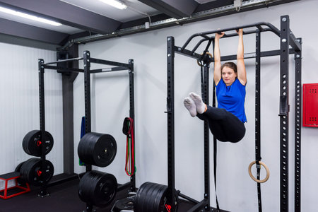 Active brunette having fun on pullup rig doing leg-raises.