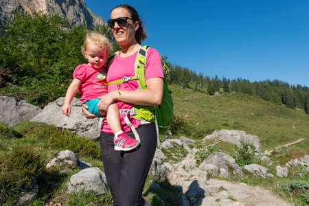 Mother and daughter hiking on a mountain path.の写真素材