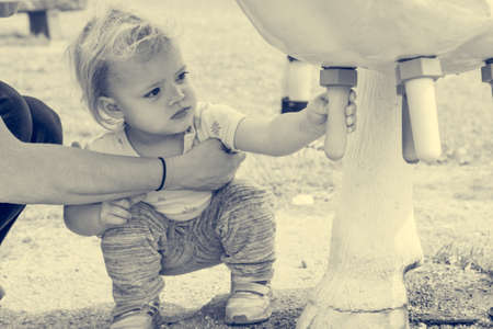 Cute blonde girl learning how to milk a cow on milking simulator.の写真素材