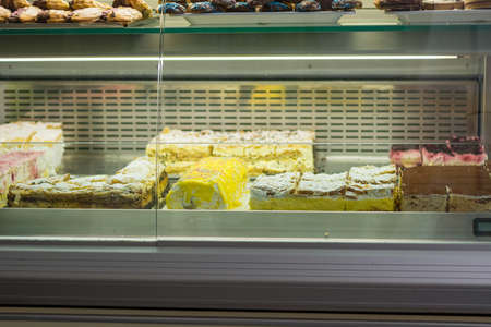 Many delicious pastry and cakes on display at local candy store.の写真素材