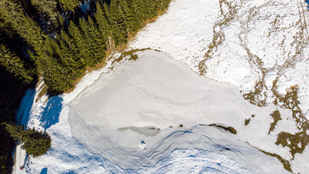 Aerial drop down view of frozen lake.