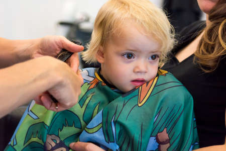 Cute blonde girl having her first haircut.の写真素材